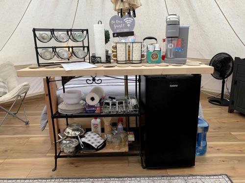 a table with a coffee maker on top of it at A Truly Glamping Experience in this Beautiful Tent in Victor, West Virginia in Victor