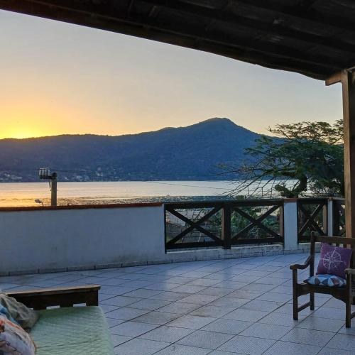 a patio with a view of the ocean and a mountain at Pousada Green in Florianópolis