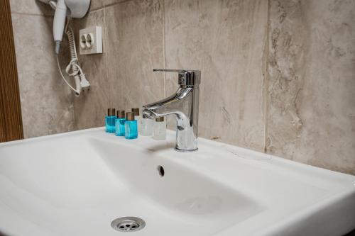 a bathroom sink with a faucet and toothbrushes on it at Crown Taksim Hotel in Istanbul