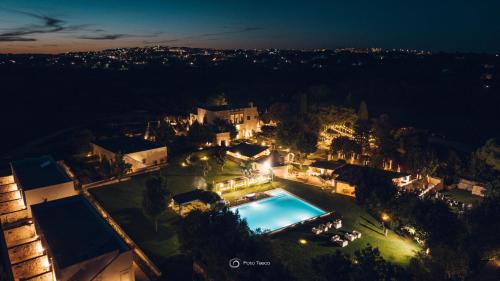 an aerial view of a house with a swimming pool at night at Relais Masseria Villa Cenci in Cisternino