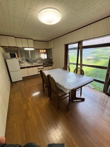 Una cocina y un comedor con mesa y sillas. en Guesthouse今井邸, en Tonami