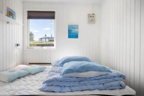 a bedroom with a bed with blue sheets and a window at LF14058-Roslev-Eskovvej-58 in Flovtrup