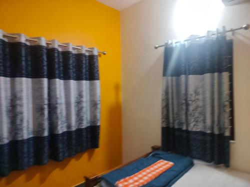 a bathroom with black and white shower curtains at Krishnamandiram in Paravūr