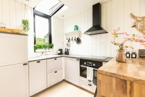 a kitchen with white cabinets and a stove at Onder het dak van Brabant in Mierlo