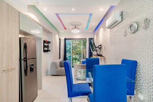 a dining room with a table and blue chairs at Cozy Apartment near Downtown Center in Santo Domingo