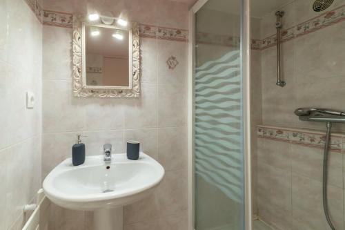 a bathroom with a sink and a shower with a mirror at LE SCENARIO - Appt city center with parking in Carentan
