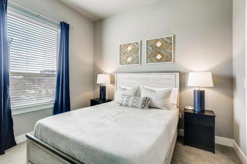 a bedroom with a bed with two lamps and a window at One Bedroom Downtown Luxury Apartment - Fast Wi-Fi - Free Parking in San Antonio