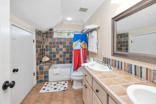 a bathroom with a toilet and a sink and a mirror at 12 Live Oak Place in Demere Park