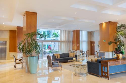 a lobby with furniture and plants in a building at Windsor Brasilia Hotel in Brasilia