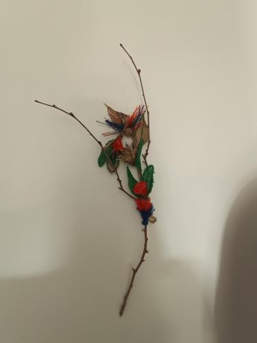 a branch with feathers on it on a white wall at Apartamento duplex único en Carmelo in Carmelo