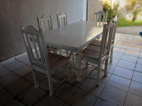 un tavolo in legno con quattro sedie intorno di Alojamento Maceió a Maceió