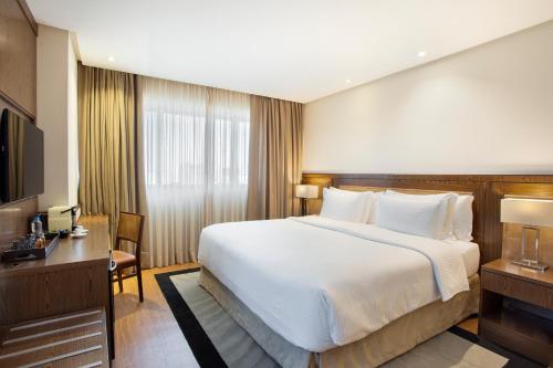 a hotel room with a large bed and a desk at Windsor Brasilia Hotel in Brasilia
