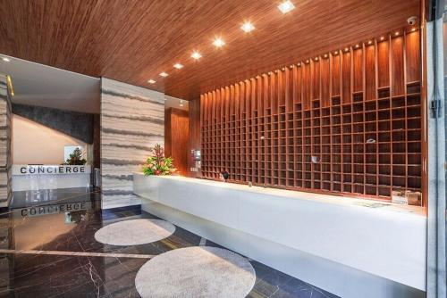 a large bathroom with a tub and a tile wall at Studio 818 no edf. TIME, Ponta Verde in Maceió
