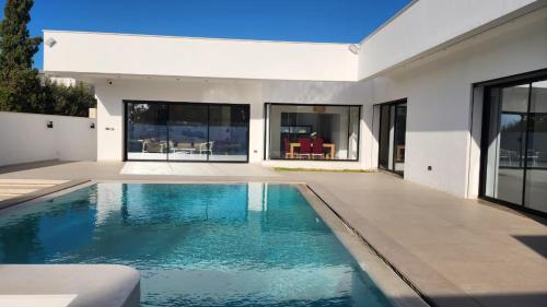 a swimming pool in the backyard of a house at Villa Elyssa Hammamet in Hammamet