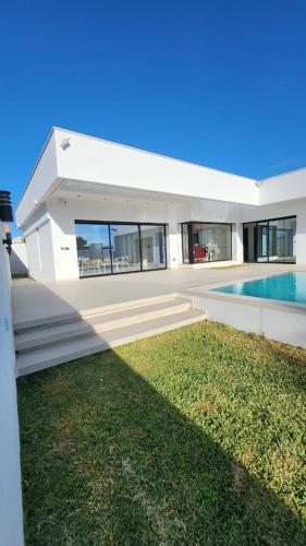 a large white house with a swimming pool at Villa Elyssa Hammamet in Hammamet