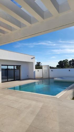 a swimming pool in the middle of a house at Villa Elyssa Hammamet in Hammamet