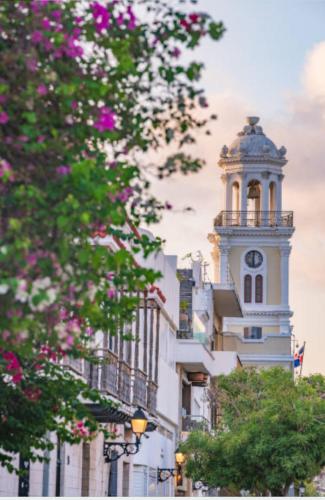 a tall white building with a clock tower at JM GUESTHOUSE Colonial in Santo Domingo