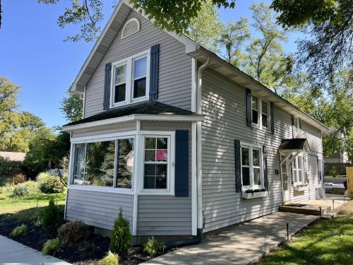 a small house with whiteiding and blue windows at Merchant Street Retreat in New Buffalo