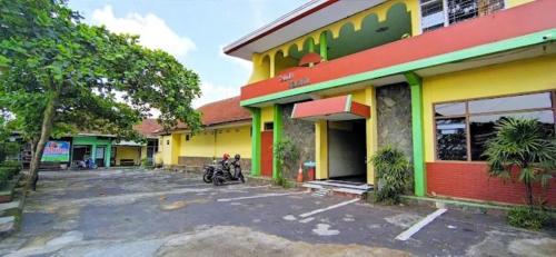 a motorcycle parked in a parking lot in front of a building at Hotel Budi Famili Budget Syariah in Ciamis