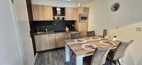 a kitchen with a wooden table with chairs and a dining room at Lavendel Huisje in Herkingen