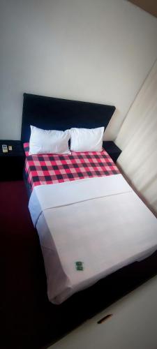 a bed with a red and black checkered blanket at Cuba linda, alojamiento, hospedaje 3 habitación económico in Asuncion