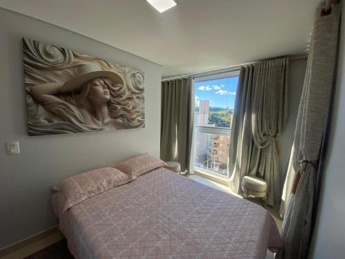 a bedroom with a bed and a large window at Apartamento ACONCHEGANTE para família em Piratuba - Brisa Do Sol - Apto 401 in Piratuba