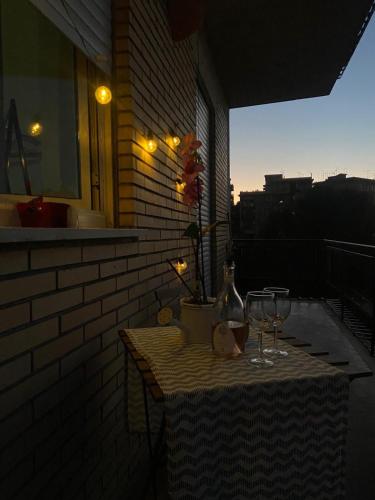 a table with two wine glasses on a balcony at Marianna Guest House in Bracciano