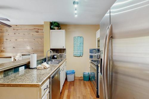 a kitchen with a stainless steel refrigerator and wooden walls at River Mountain Lodge #W101 in Breckenridge