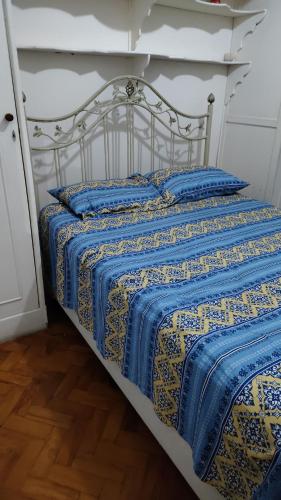 ein Bett mit einer blauen und gelben Decke darauf in der Unterkunft Brazil Cozy and Comfortable in Rio de Janeiro