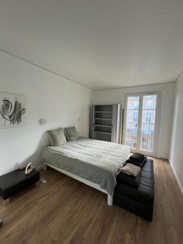 a white bedroom with a bed and a couch at UNESCO Le Havre Appartement 100m2 in Le Havre
