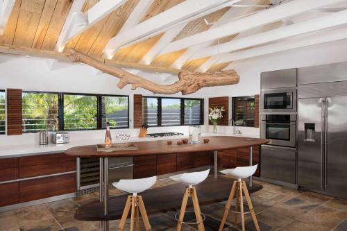 a kitchen with a wooden counter and stools at Spectacular spacious 8 bedroom family villa in Providenciales