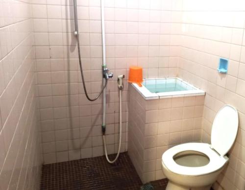 a bathroom with a shower with a toilet in it at Hotel Budi Famili Budget Syariah in Ciamis