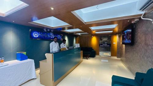 two men standing at a bar in a restaurant at Hotel Park Valley International in Ābdullāpur