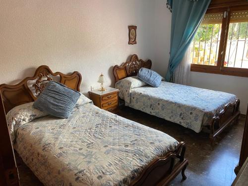 a bedroom with two beds and a table with a lamp at Casa-Villa en Lorca relax vistas y piscina privada in Lorca