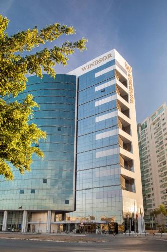a tall glass building with a sign on it at Windsor Brasilia Hotel in Brasilia