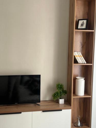 a flat screen tv sitting on top of a white cabinet at Уютная студия в жк Four Seasons in Zhezdi
