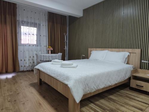 a bedroom with a large bed and a chair at Casa Angela in Giarmata