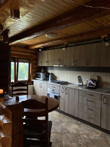 ポイアナ・ネグリイにあるCasa Brindusaのキッチン(テーブル、コンロ、キャビネット付)