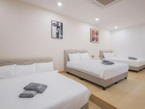 two beds in a room with white walls at 30 PAX Perling Party House #Miao Nalisa# in Johor Bahru