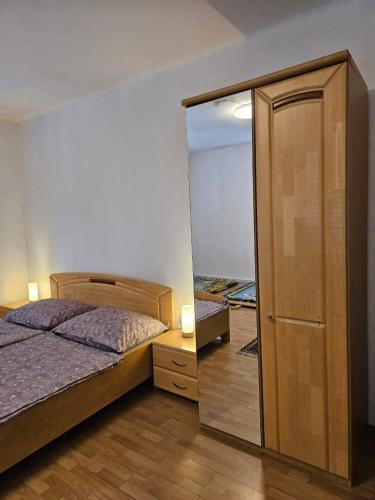 a bedroom with a bed and a closet and a mirror at Ferienwohnung Villach Süd in Villach