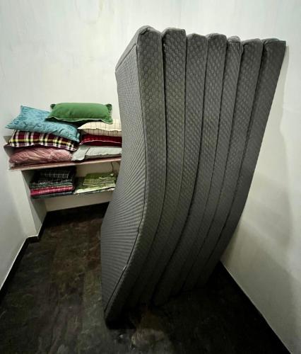 a couch sitting in the corner of a room at 2BHK Farm Villa In Kovai Kuttralam Mainroad Near ISHA By Shivalaya in Coimbatore