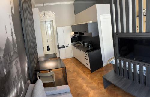 a living room with a television and a kitchen at Holec Apartments in Prague