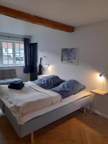 Una cama o camas en una habitación de Mini-lejlighed med køkken - delt bad og toilet med nabolejlighed