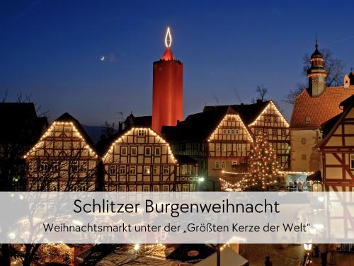 a lit up town with a christmas tree and a clock tower at STORCHENNEST - Scandi Style - in der historischen Hinterburg Schlitz - mit Aufzug, Parkplatz & Garten - nahe Fulda und Bad Hersfeld in Schlitz