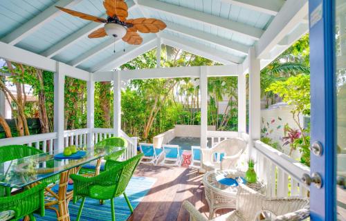 a porch with a table and chairs and a ceiling fan at Bahama House in Key West