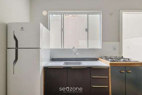 a kitchen with a refrigerator and a sink at Conforto e Comodidade no Centro de Itajaí - CARs in Itajaí