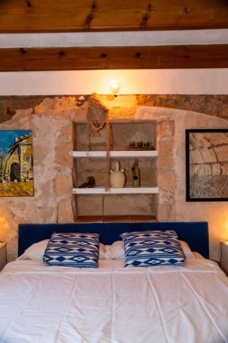 a bedroom with a bed in a stone wall at Isla privada, Menorca in Fornells