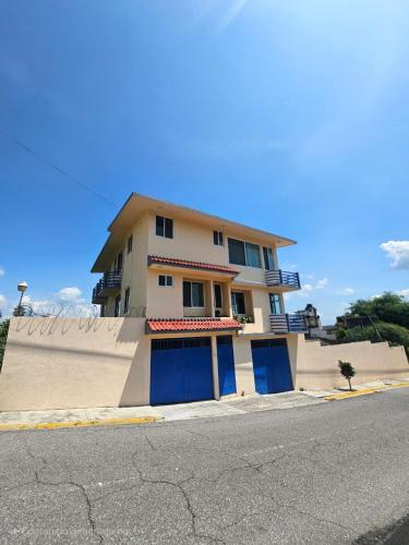 a building with blue doors on the side of a street at Preciosa casa para Descanso en Tequesquitengo in Tequesquitengo