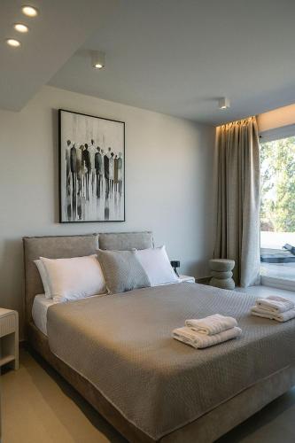 a bedroom with a bed with two towels on it at Zeus Jacuzzi Sea View Rooftop in Kontokali