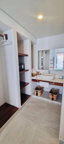 a white bathroom with a sink and a tub at Beachfront White Villa in Playa Blanca in Zihuatanejo